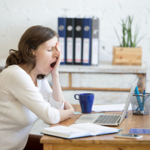 woman yawning at desk