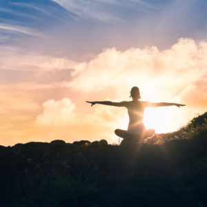 woman doing yoga poses at sunrise