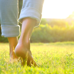 A woman walks on sunny grass