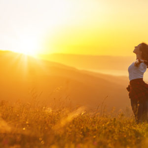 woman stretching into sunshine