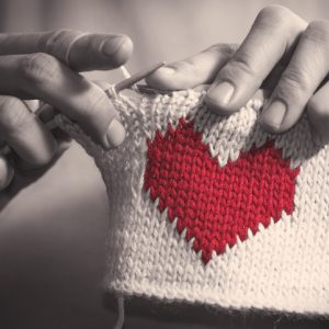 Woman knitting a heart for craftivism