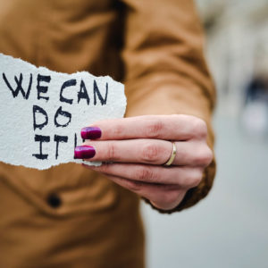 Woman holding We Can Do It sign