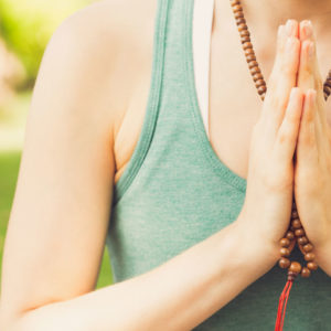 Woman practicing yoga with mala beads