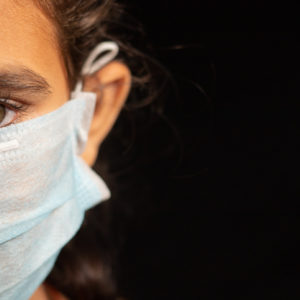 eyes of young girl child with medical mask wearing, protection against covid 19