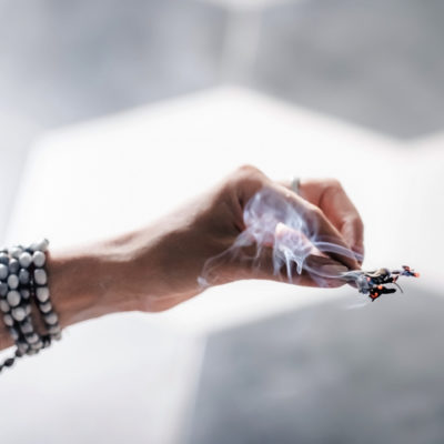 Woman's hand burning herbs