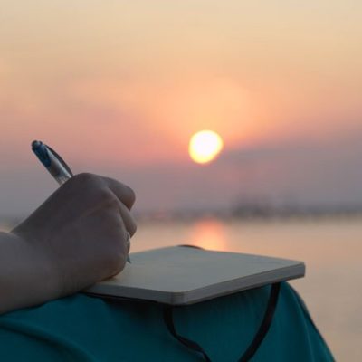 Woman journaling at sunset