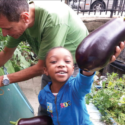 Girl with eggplant in garden