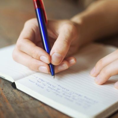 Hand writing in journal from spiritual journaling prompts