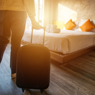 person with suitcase arriving in room at retreat