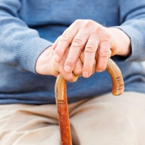 Elderly persons hands on cane