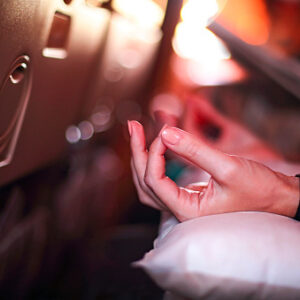 Person in airplane meditating to relax and find zen