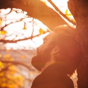 Man relaxing against tree