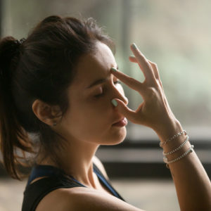 Woman doing yoga using alternate nostril breath technique