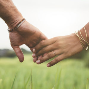 couple holding hands in field