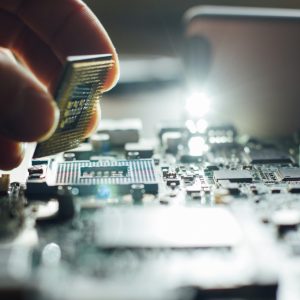 Technician plugs in a CPU microprocessor to a motherboard socket.