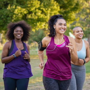 Group of female friends jogging together at park.