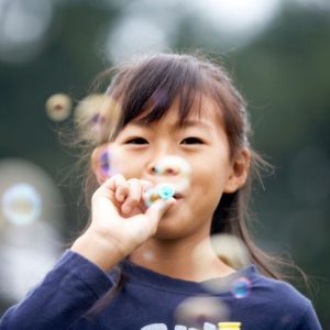 Young japanese girl blowing bubbles