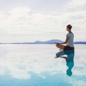 Calm scene of woman meditating on water