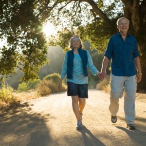 Mature couple holding hands on dirt road