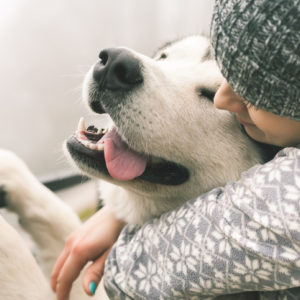 girl hugging dog