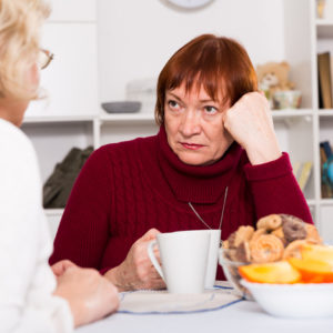 Stressed looking woman having coffee with her friend