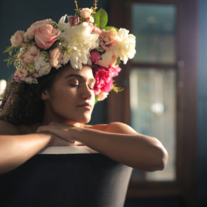 Woman wearing a flower crown soaking in the bath