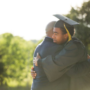 father hugging graduate