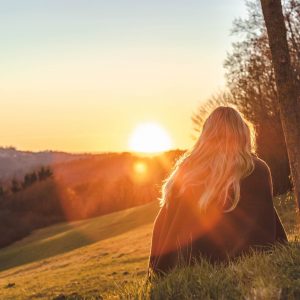 Woman watches sunrise tapping spiritual power of the sun