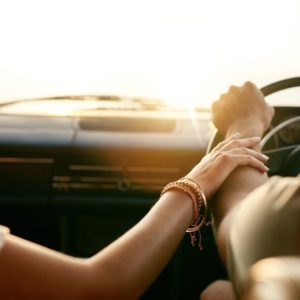 Young couple holding hands in car