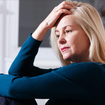 An anxious woman is deep in thought