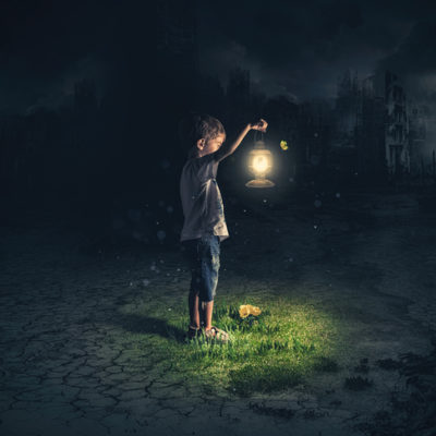 a boy navigates the darkness with a lantern