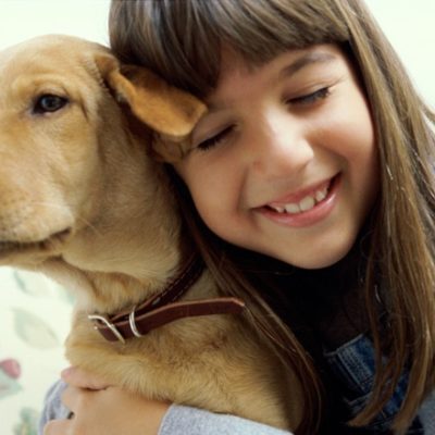 Young girl giving puppy a spiritual hug