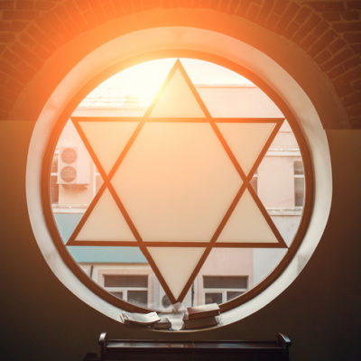 Window in synagogue in form of Star of David, six-pointed star with sunlight, Jewish symbol - stock photo