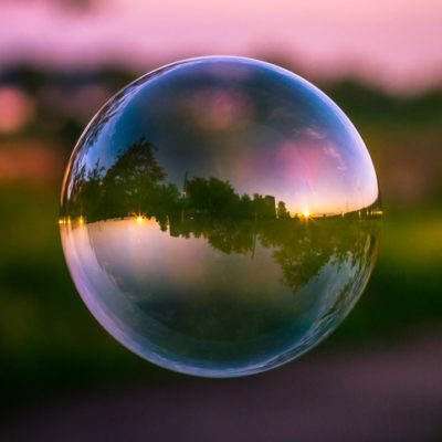 Reflection of a colorful sunset sky inside a soap bubble