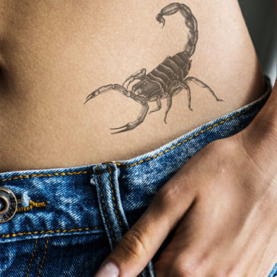 Closeup of hip tattoo of a woman featuring a scorpion