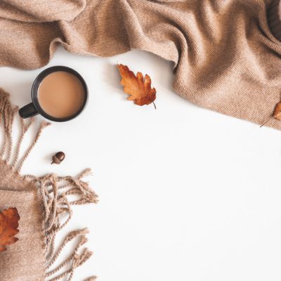 An autumn composition: cup of coffee, plaid, autumn leaves to show the yin of fall