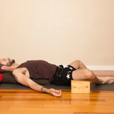 Man in supported fish yoga pose