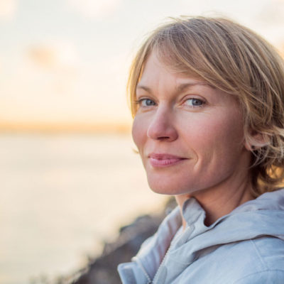 Woman smiling contently at sunset