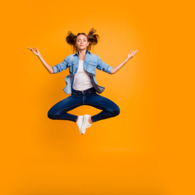 woman in meditation pose joyfully is in the air