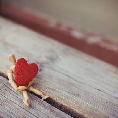 Wood figure holding red heart