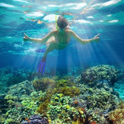 Woman swimming in coral reef