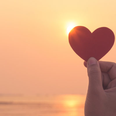 Woman holding heart to light