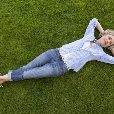 woman relaxing on green grass lawn