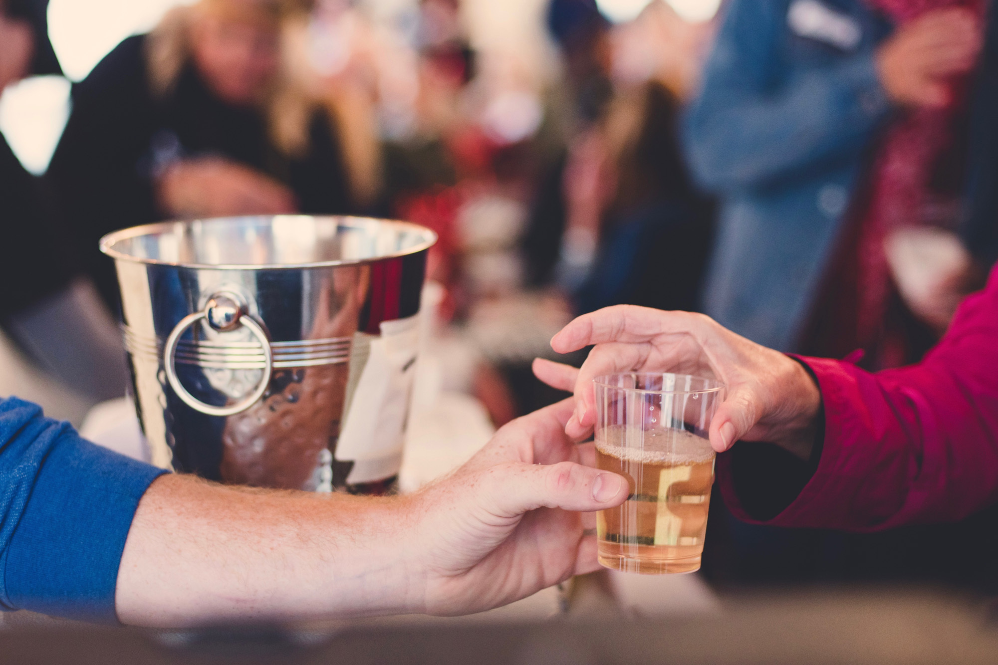 A person handing someone a glass of wine at a private event