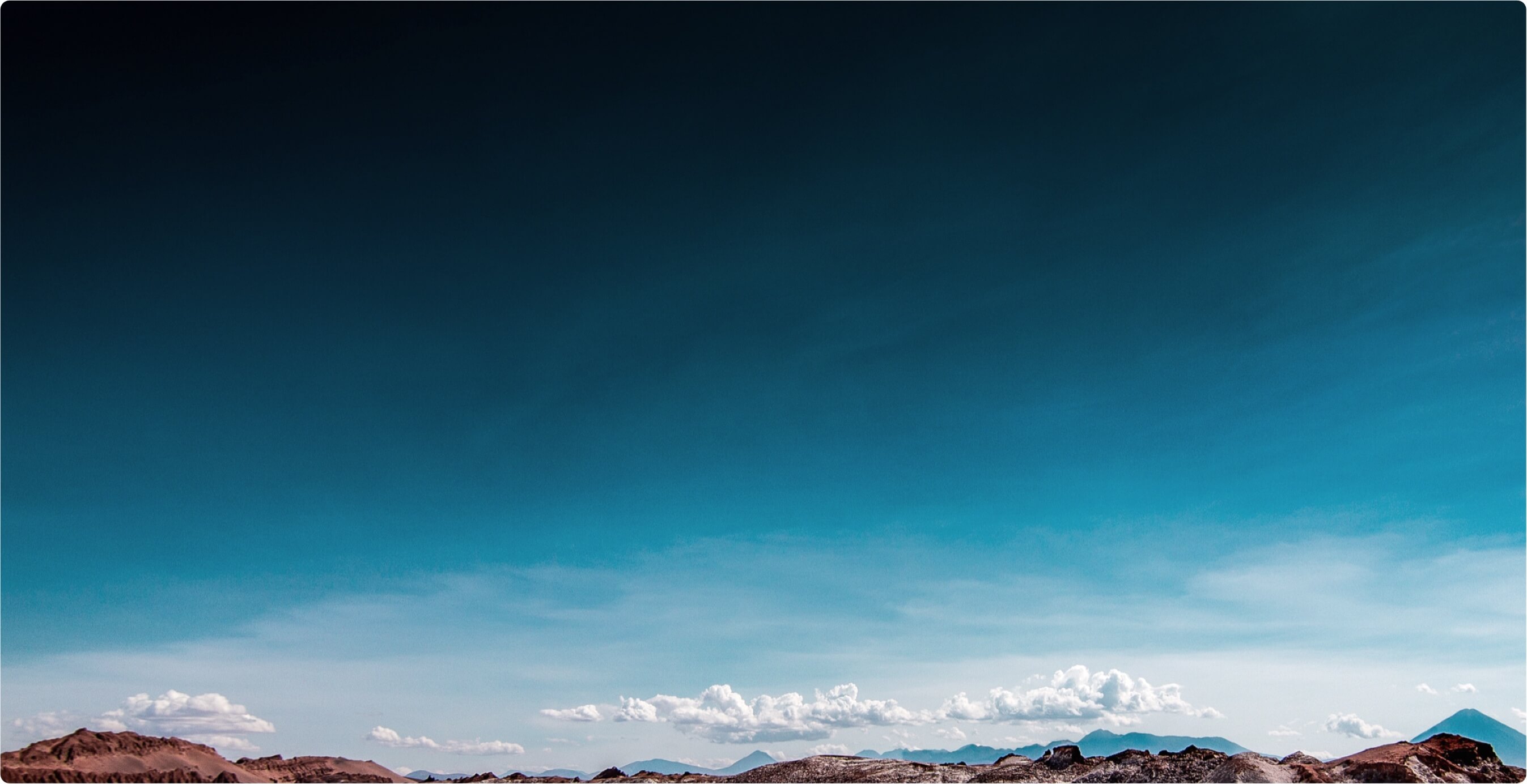 Mountain range against blue sky and clouds