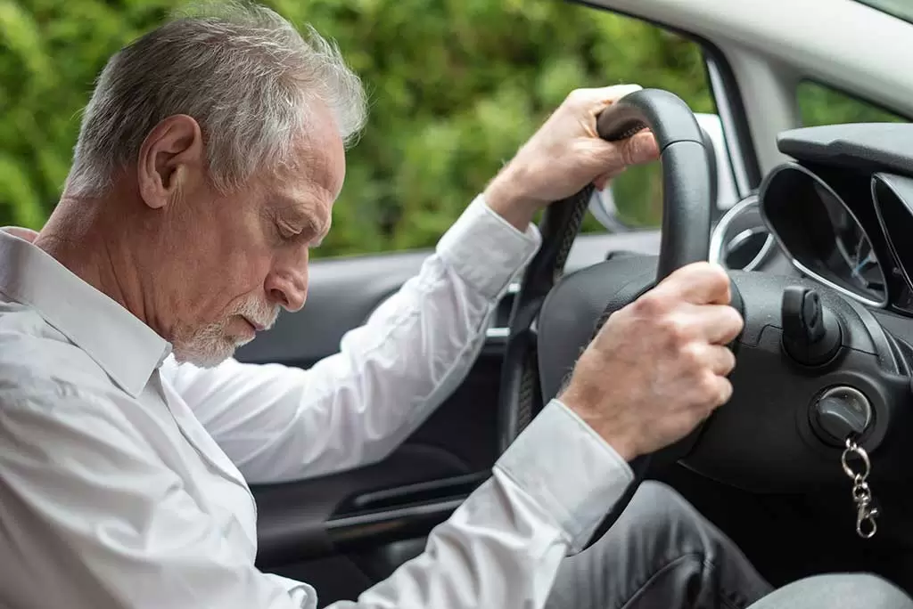 tired-man-falling-asleep-in-car.webp