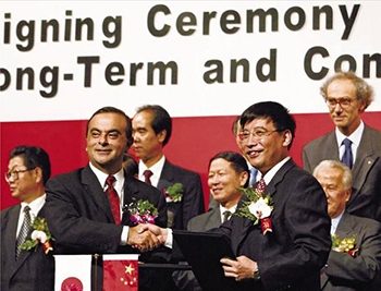 Carlos Ghosn shakes hands with an executive of  Dongfeng Motor, Nissan's joint-venture partner in  China.