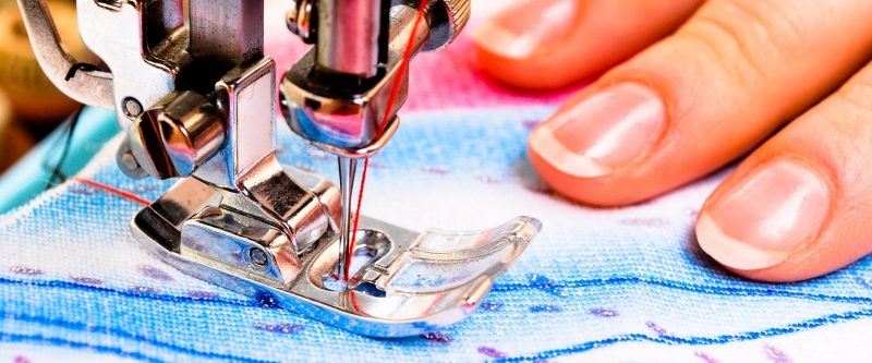 Close up of woman using sewing machine