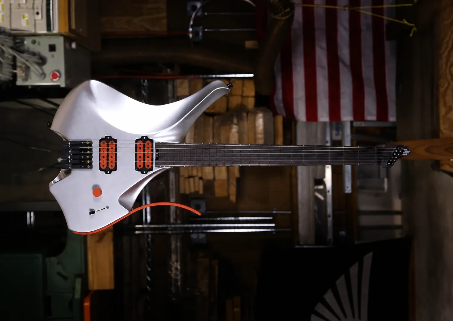 Silver Headless Virtus guitar with orange accents