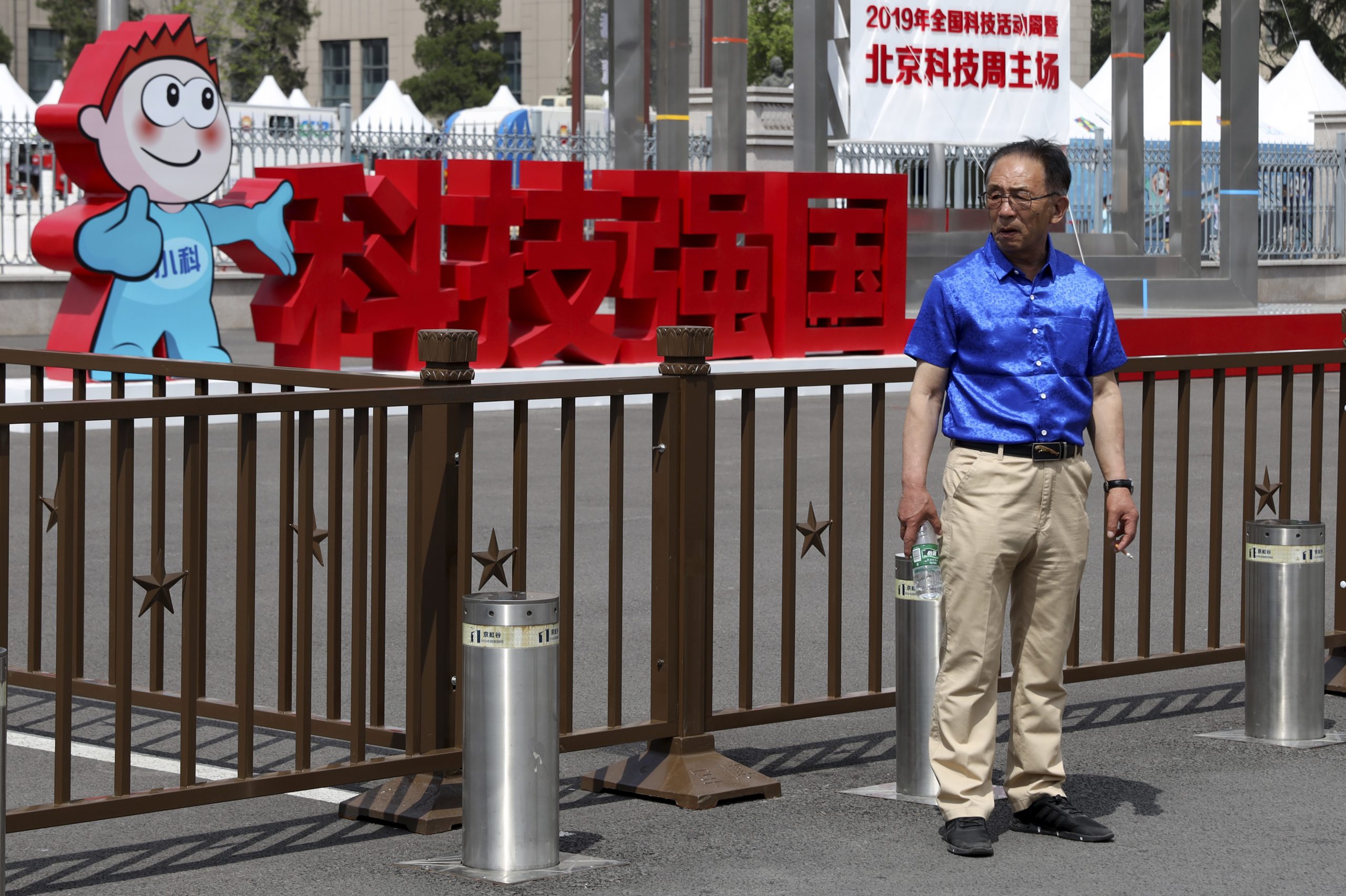 圖／一名男子站在中國軍事博物館外北京科技週「科技強國」標語前。（AP Photo / Ng Han Guan / 達志影像）